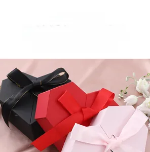 Three elegant heart-shaped gift boxes in black, red, and pink with ribbon bow details