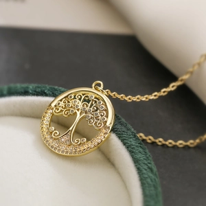 18K gold plated tree of life necklace with zircons displayed in a green velvet jewelry box