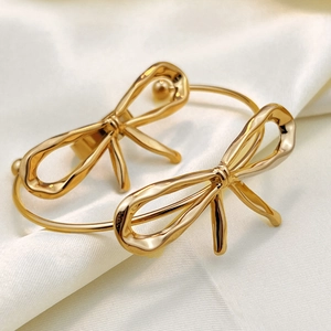 Elegant 18K gold plated bow cuff bracelets with hammered texture on silk fabric
