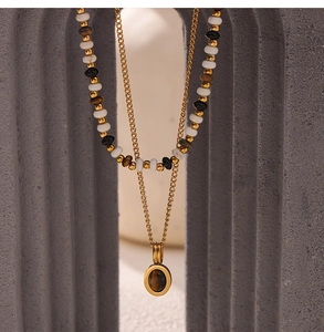 Double-layered gold chain necklace with tiger eye stone pendant and mixed beads on display