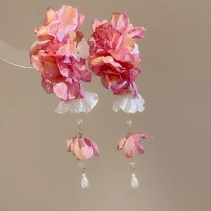 Vue détaillée de la pince à cheveux à fleurs en tissu rose et orange avec perles