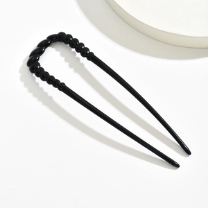 Minimalist black U-shaped hair pin with top bead detail shown on a clean white background