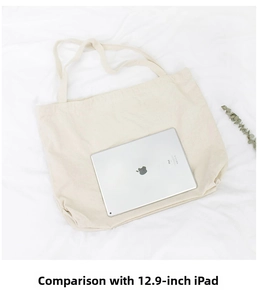 Detailed size view of canvas tote bag fitting a 12.9-inch iPad on a white fabric surface