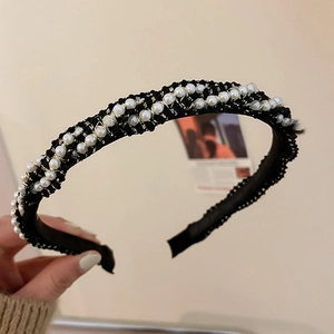 Detail of black woven headband with rows of small white pearls and gold wire wrap