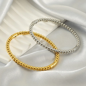 Detail of minimalist stainless steel beaded bracelets in gold and silver finish