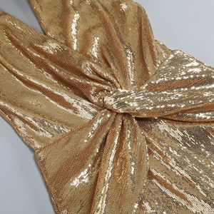 Detailed view of the gold sequined jumpsuit featuring a waist twist knot design