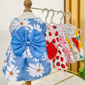 Detail view of multi-color pet dresses with daisy prints and large decorative bows