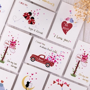 Vintage kraft paper cards with dried flowers and romantic I Love You text on wood