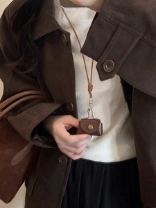 Detail shot of brown leather croissant mini bag pendant with woven necklace lanyard