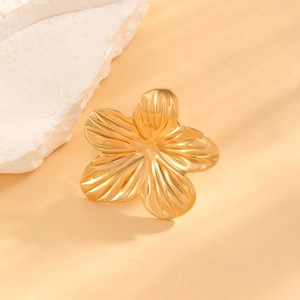 Detailed macro view of the golden flower ear cuff with delicate petal texture and glossy finish