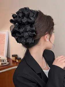 Détail de la pince à cheveux noire à fleurs multicouches en texture de soie
