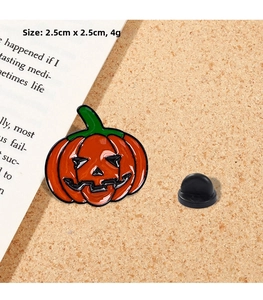 Detail of Jack-o'-lantern enamel pin with dimensions 2.5cm by 2.5cm and green stem
