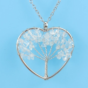 Detail of silver wire-wrapped heart pendant with tree of life and crystal stones