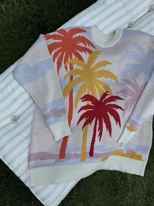 Close-up of palm tree jacquard knit sweater featuring vibrant color-block tropical patterns