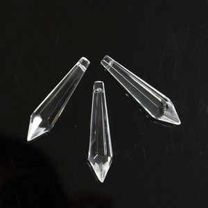 Close-up of three faceted crystal prism pendants for DIY decor on a black background