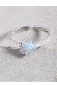 Dettaglio macro dell'anello in argento S925 con opale a cuore e fascia testurizzata