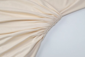 Gros plan détaillé du tissu en maille abricot avec plis raffinés et texture soyeuse