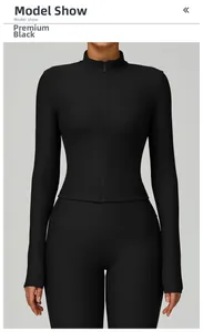Close-up of premium black ribbed fabric on slim fit zip-up yoga jacket and leggings set
