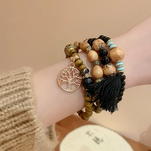 Close-up of Bohemian multi-layer sandalwood beaded bracelet with tree of life charm and tassel