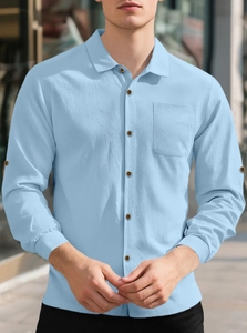 Detail of light blue linen shirt featuring wood-style buttons and a chest pocket