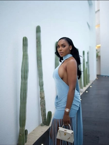Detail of light blue halter backless mini dress with long fringe tassels on the hemline