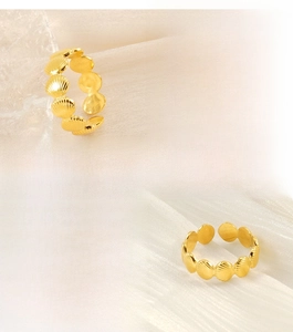 Detailed close-up of golden stainless steel ring featuring textured seashell relief patterns