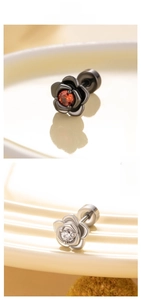 Gros plan de boucles d'oreilles fleurs noires et argentées avec pierres de zircon