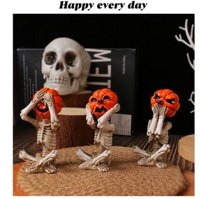 Detailed view of three pumpkin skull figurines in see-no-evil poses for Halloween decor