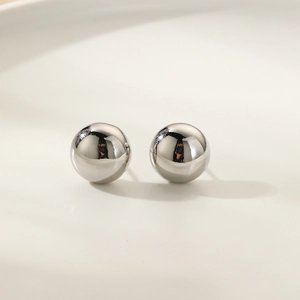 Macro shot of polished silver spherical stud earrings with a glossy mirror finish