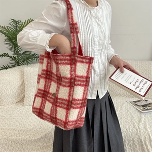 Detailed view of the red and white checkered fleece tote bag in a cozy home setting