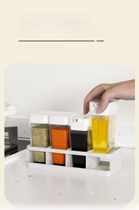 White four-slot kitchen seasoning organizer tray with transparent spice jars and oil bottles