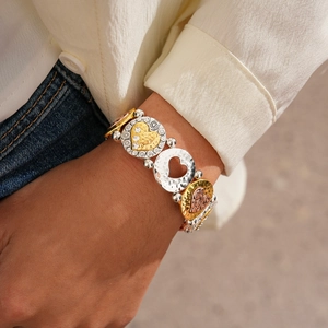 Gros plan d'un bracelet cœur tricolore avec texture martelée et pierres scintillantes