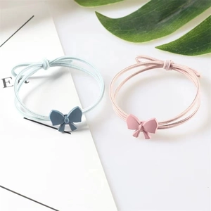 Elastic hair ties featuring pastel blue and pink matte bow ties on a fresh white surface