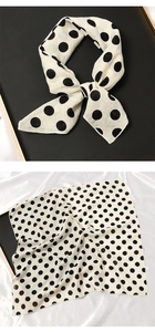 Détail d'un petit carré de coton et lin blanc à pois noirs noué en forme de nœud
