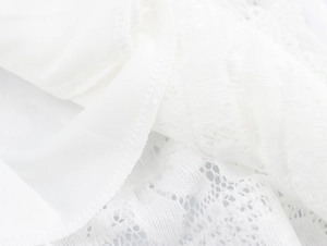 Gros plan sur la dentelle française blanche et la texture tricotée d'une robe de vacances