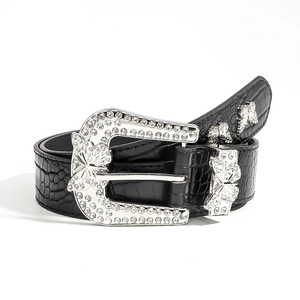 Detail of black faux crocodile leather belt with sparkling rhinestone butterfly buckle