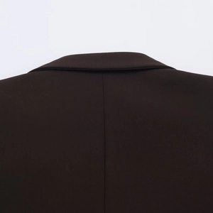 Gros plan détaillé de l'encolure arrière et du tissu en sergé fin d'un blazer sombre