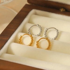 French vintage style 18K gold and silver beaded hoop earrings on a wooden jewelry display
