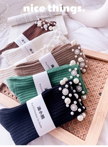 Detailed view of knitted mid-calf socks with elegant pearl and flower bead decorations