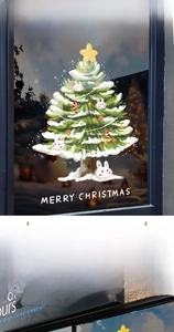 Detailed view of Merry Christmas tree and rabbit static stickers on a glass window