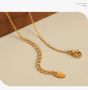 Close-up of gold-plated stainless steel necklace lobster clasp and S.steel hallmark tag