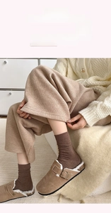 Detail of warm brown shearling slippers and ribbed cotton socks for winter comfort