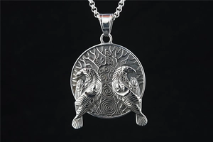 Macro shot of Viking pendant with two ravens on tree of life over black background