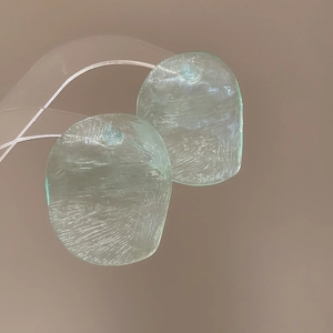 Macro shot of irregular oval light green resin earrings with unique ice crack texture