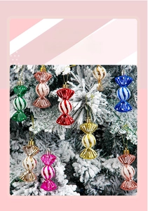 Detail of colorful electroplated candy ornaments with white stripes on a snowy Christmas tree