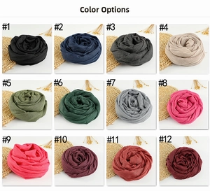 Color display of twelve pure cotton linen scarves arranged in rose shapes on woven mats