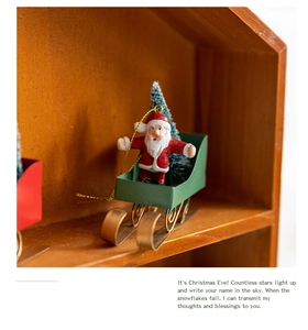 Detailed view of a red and green miniature Christmas sleigh ornament in a wooden box