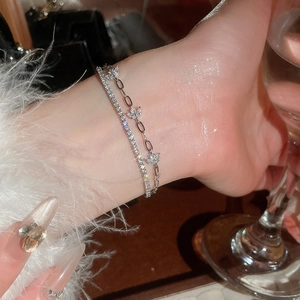 Close-up of elegant double-layered 18k gold plated bracelet with zircon flower charms