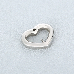 Detailed close-up of a silver stainless steel heart-shaped charm with cutout design