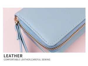 Close-up of light blue leather wallet texture with fine stitching and golden zipper